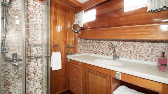 Modern bathroom with stylish mosaic design on Gulet Nikola. Comfort and luxury onboard.