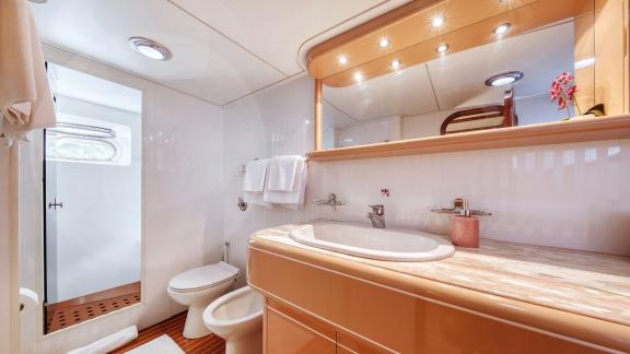 The spacious bathroom of motor yacht Custom Blanka features a modern sink and shower area.