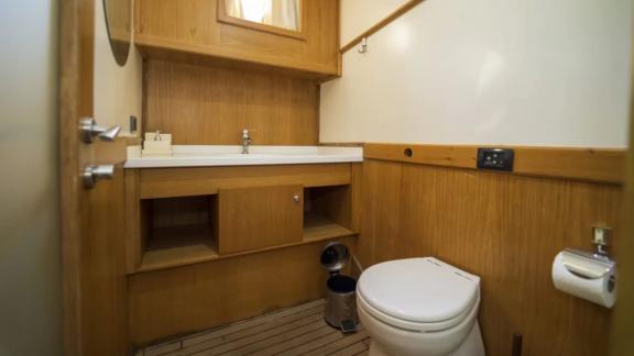 Modern bathroom of the Gulet Happy Hours with wood panelling.