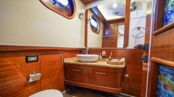 Gulet La Bella equipped with luxurious wood panelling, large mirror and modern amenities.