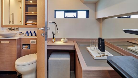 Modernes Badezimmer auf der Yacht Elly mit elegantem Design und einem angrenzenden Arbeitsbereich.