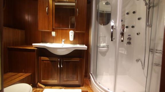 Modernes Badezimmer auf einer Yacht mit einer luxuriösen Dusche und eleganter Holzverkleidung.