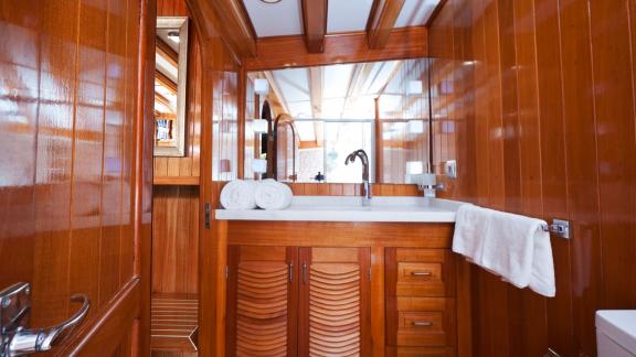 A modern bathroom on board the Flas VII with elegant wood panelling and a spacious wash area.