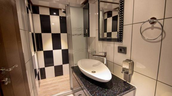 Nevra Queen'de duş ve şık lavabo armatürü ile modern banyo.