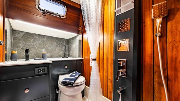 Elegant bathroom with shower, sink, and porthole on Gulet Golden Joy in Bodrum.