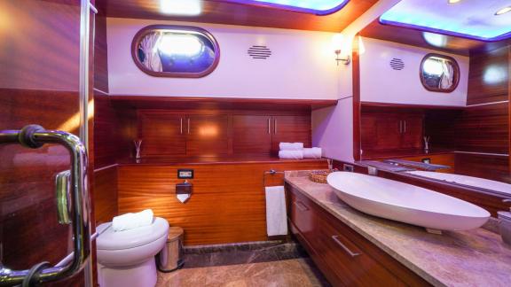 An elegant bathroom on the gulet La Bella Vita in Bodrum, with fine wood panelling, modern washbasin