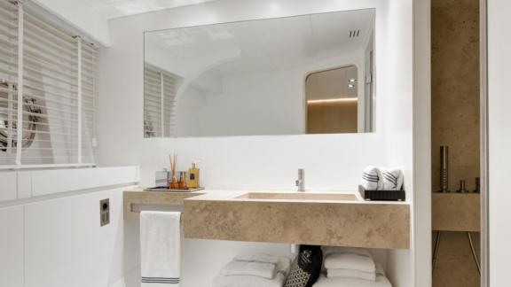 Şık armatürler ve büyük aynaya sahip Atlantika'da modern, aydınlık banyo.