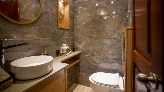 Modern bathroom of the Gulet Diva Deniz with fine marble elements, stylish washbasin and large mirror.