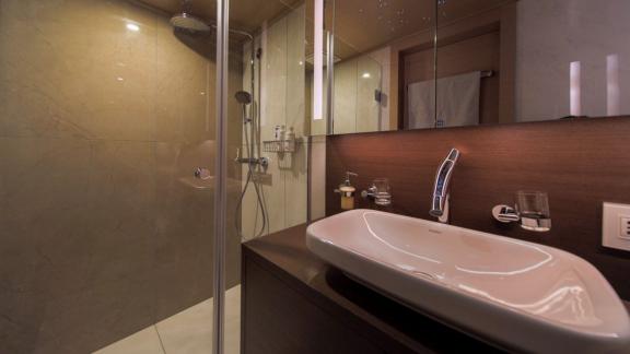 Modern bathroom on Omnia with a large shower and stylish sink.