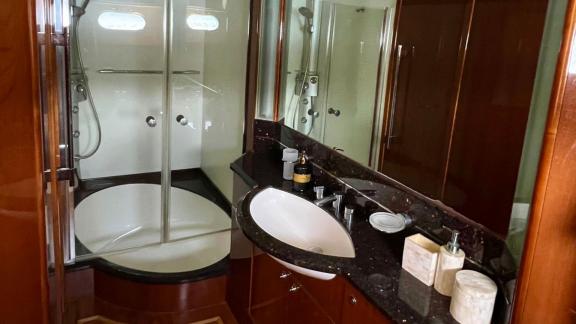 Freya motoryatın banyosu, geniş duş kabini, mermer lavabo ve kaliteli aksesuarlarla donatılmış modern ve şık bir alan su