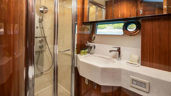 The Sunseeker 75 features a modern bathroom with glass shower, sleek sink and forest-view window.