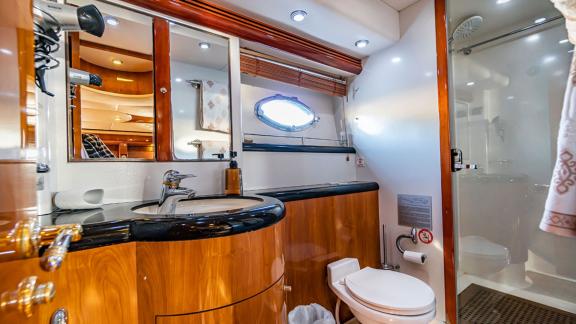 The bathroom of the Edition yacht features a large mirror, modern sinks, and a stylish shower area.