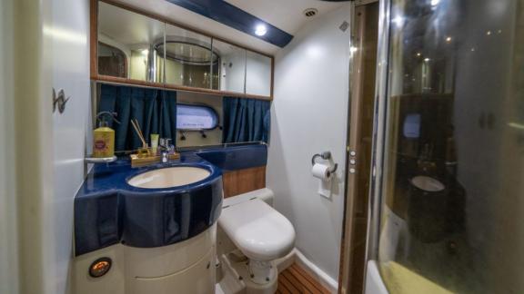 The bathroom of Karan motor yacht features a stylish sink and glass shower cabin with a modern design.