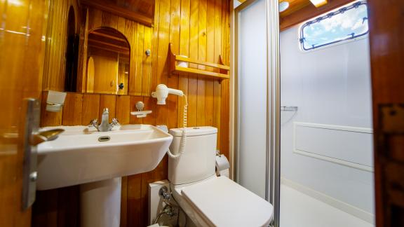 Enjoy the comfort of a modern bathroom on Gulet Ya Selam with wooden paneling.