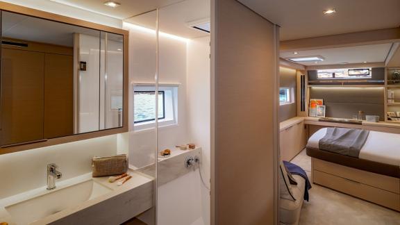 View of a luxurious bathroom and a modern yacht cabin with elegant furnishings and large windows.