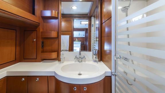 Modern bathroom with wood panelling and shower on a luxury sailing yacht.