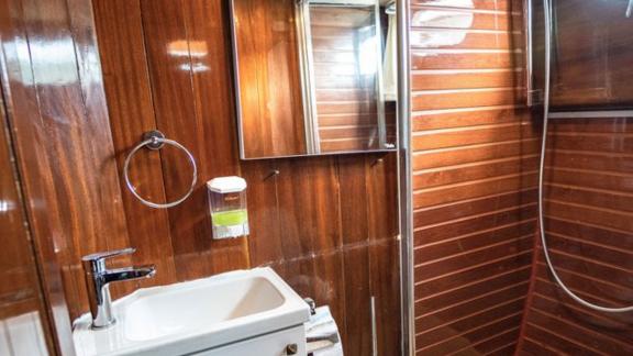 Modern bathroom on Gulet Thalasa with sink, mirror, and shower.