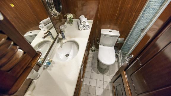 Modern bathroom with shower and elegant wooden furnishings on the gulet Duramaz in Fethiye.