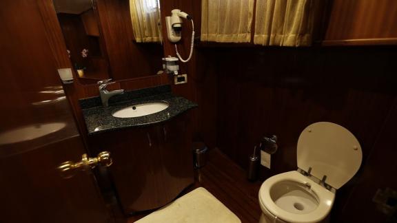 Stylish bathroom with modern amenities and elegant wood paneling on Gulet İlknur Sultan.