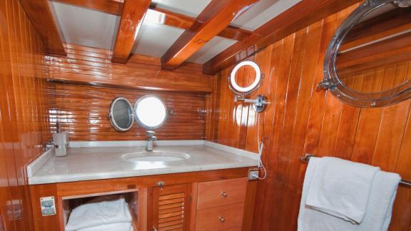 Enjoy the comfort of the modern bathroom on Gulet Myra with elegant wood paneling.