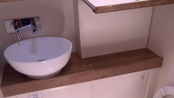 The bathroom of the Taurus 6 yacht features a modern sink and stylish wooden details.