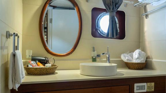 Gulet Bella Mare in Bodrum, with a round mirror, modern fittings and practical storage baskets.