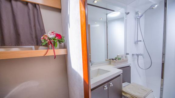 The modern bathroom of catamaran High Five features a spacious shower area and stylish decor.