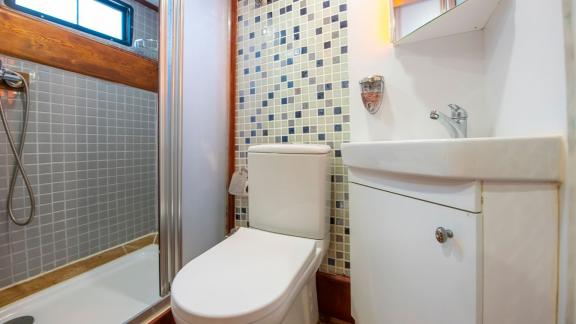 The modern bathroom on Gulet Rüya with a shower, toilet, and stylish mosaic tiles.