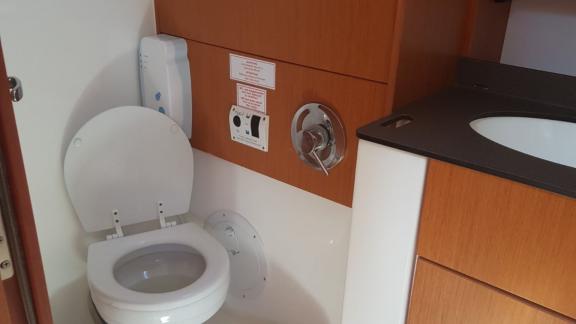 Im Badezimmer der Segelyacht Vivi befinden sich eine moderne Toilette und ein Waschbecken.