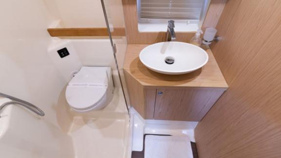 Das Badezimmer der Motoryacht Ocean Dreamer verfügt über eine Dusche, Toilette und ein modernes Waschbecken.