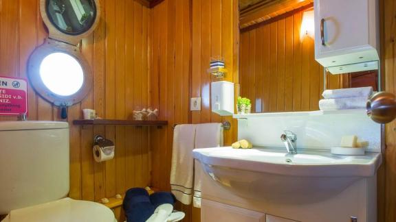 Clean and well-equipped bathroom with porthole window on a Gulet yacht. Enjoy comfort at sea.