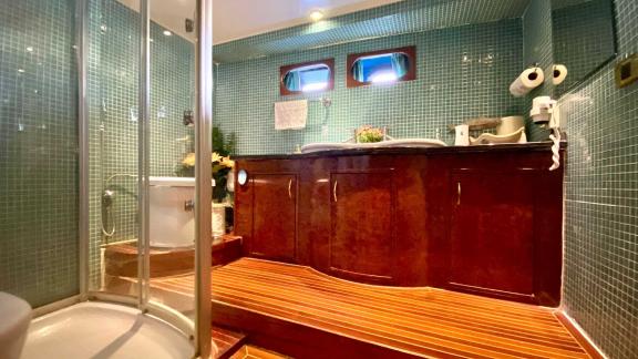 The luxurious bathroom on Vedo B yacht features a modern shower, large sink, and stylish decor.