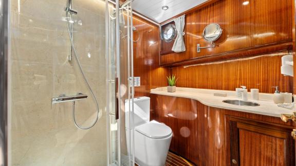 Ein stilvolles Badezimmer an Bord der Gulet Smart Spirit mit moderner Dusche, eleganter Holzverkleidung und hochwertigen