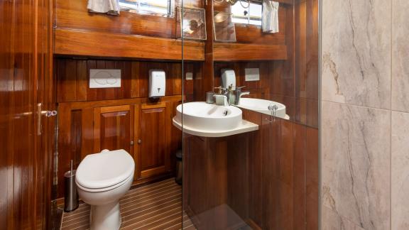 Modern bathroom with wooden accents and glass shower. Comfort and style for your holiday.