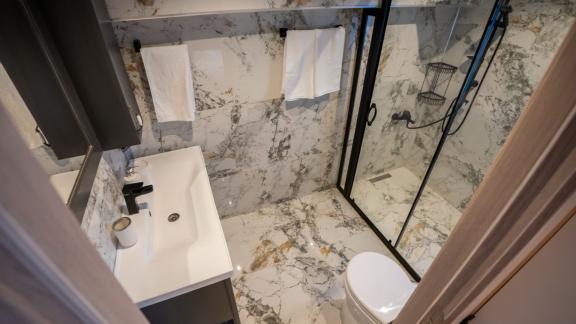 The modern bathroom of Almila motor yacht in Marmaris features marble floors and walls, with a stylish design.