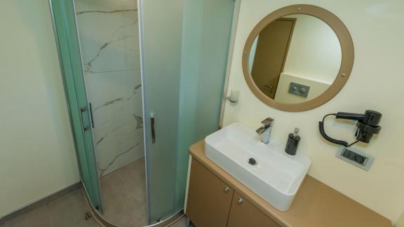 The modern bathroom of the luxury trawler Lycian Dream in Fethiye features a spacious shower and stylish sink.