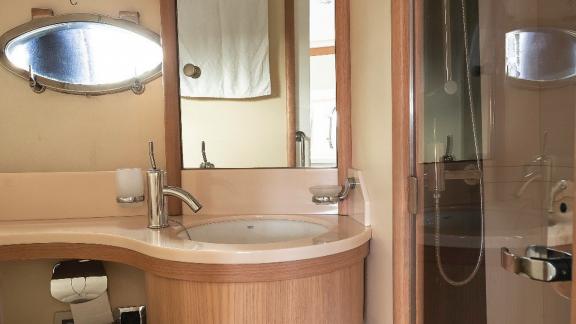 The bathroom of motor yacht Vida Boa features an elegant sink and a glass shower cabin with a stylish design.