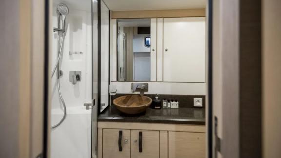 The bathroom on the Life Time yacht features a wooden sink and a spacious shower area.