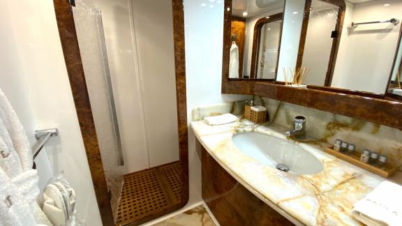 The bathroom on Paula 3 yacht offers marble details and a modern shower for comfort and style.