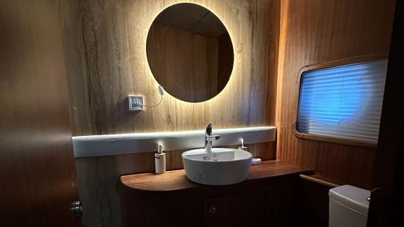 Stylish bathroom with illuminated mirror and elegant decor on the Gulet yacht.