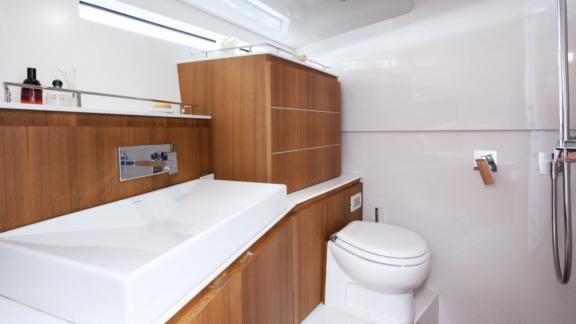 The bathroom of the Neve motor yacht features a modern design with stylish wooden cabinets.