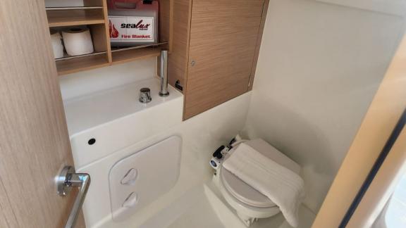 The bathroom of Lima yacht is equipped with a sink, toilet, and fire blanket.