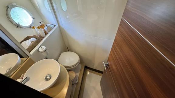 The bathroom on motor yacht Breathe features a shower, sink, and toilet.