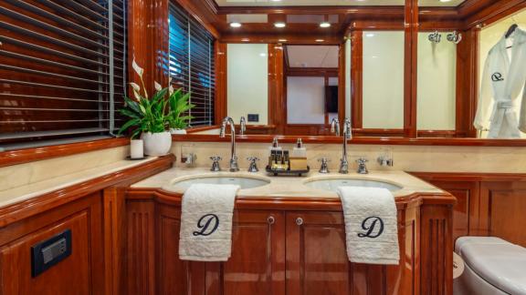 Divine yacht’s bathroom features double sinks, elegant accessories, and luxurious details.