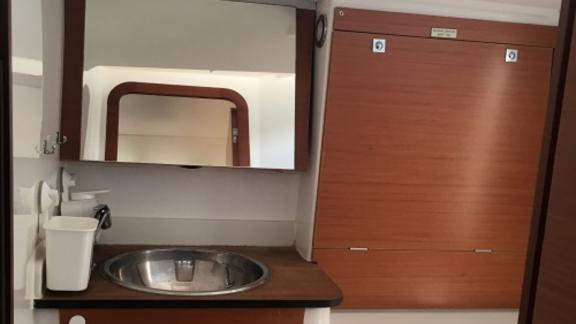 The yacht's bathroom features a sink and a large mirror.