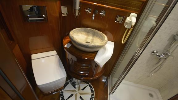 The bathroom of Queen Atlantis features a stylish stone sink and a modern shower area.