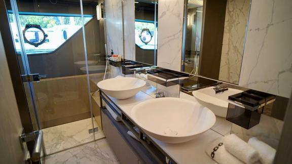 На Ferretti 850 Shero в Мармарисе просторная ванная с двумя раковинами и стеклянным душем.