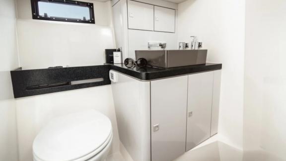 The bathroom of the Bombon motor yacht features modern fixtures and a compact sink area.