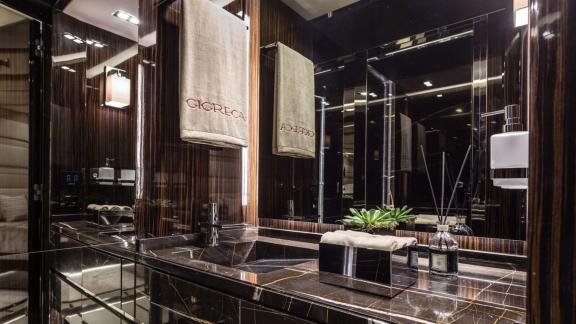 Gigreca’s bathroom stands out with dark marble and elegant details.