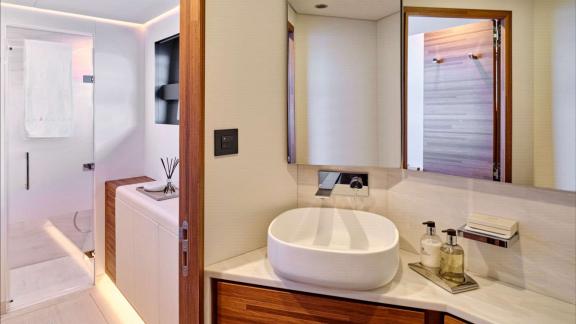 Bathroom includes a glass shower, vessel sink and mirrored cabinet.